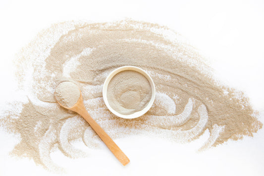 creatina monohidratada vs creapure: pó de creatina em uma tigela com colher
